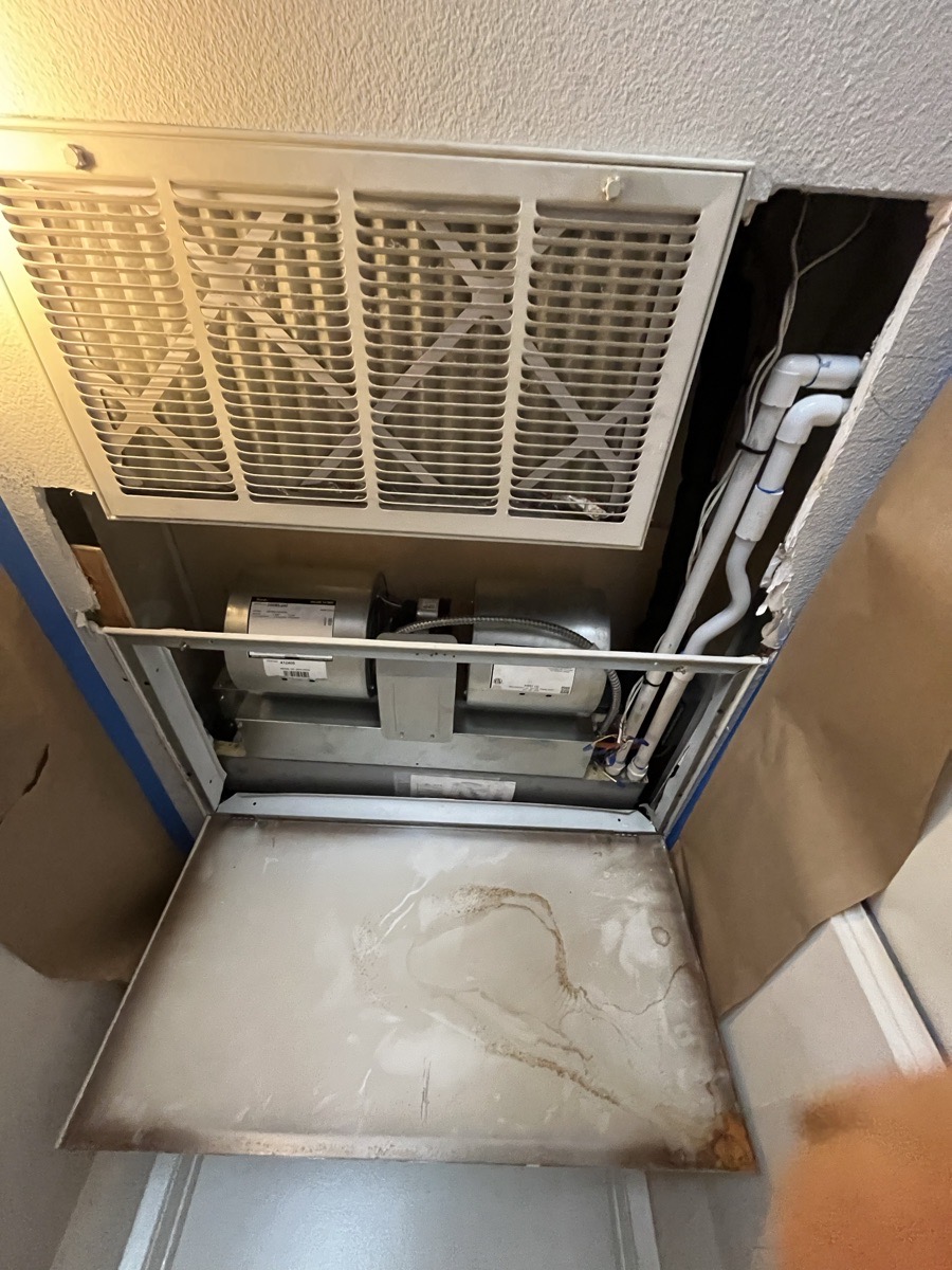 Ceiling access opening beside an air-conditioning grille before drywall closure
